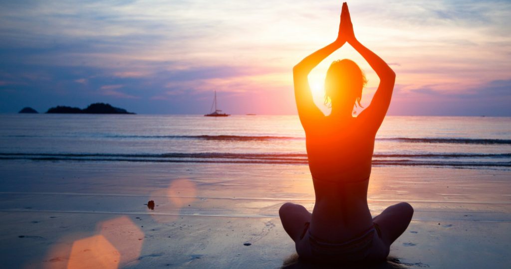 Yogini Kundalini sur la plage face au couché du soleil / © DR
